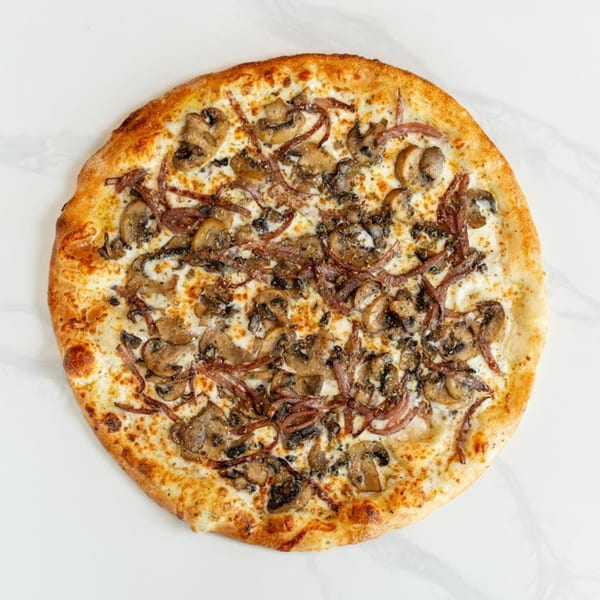 MONDO PIZZA's mushroom and caramelized onion pizza with a creamy white sauce on a white background.